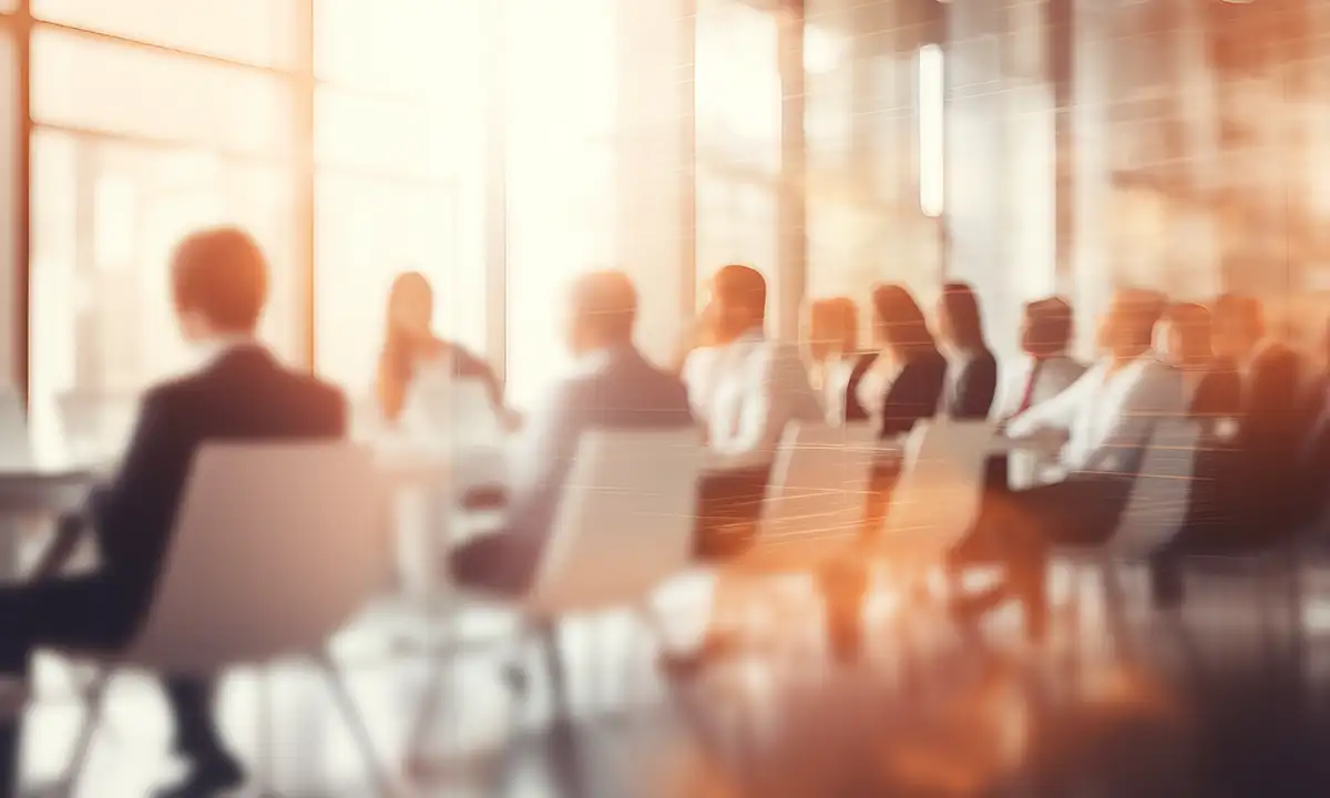 A stylized photo of many suited people sitting at a conference room table